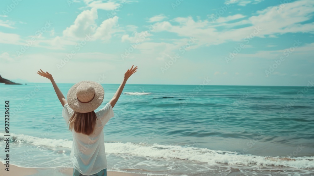 A woman, hands raised joyfully, stands before a vast ocean under a bright sky, celebrating freedom and serenity.