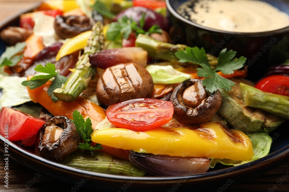 Delicious salad with grilled vegetables and sauce on table, closeup Delicious salad with grilled vegetables and sauce on table, closeup