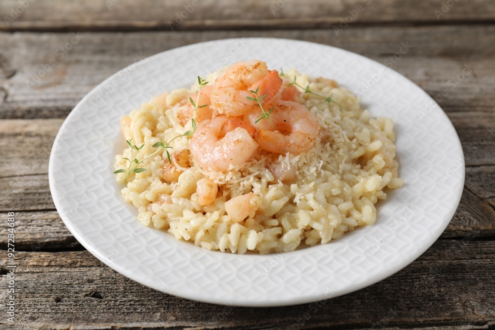 Delicious risotto with shrimps and cheese on wooden table, closeup Delicious risotto with shrimps and cheese on wooden table, closeup