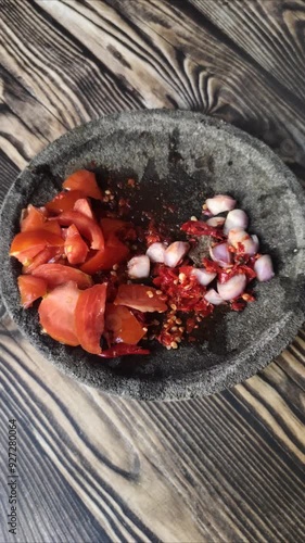 Making Tomatoes Chili sauce in stone mortar and pestle. 