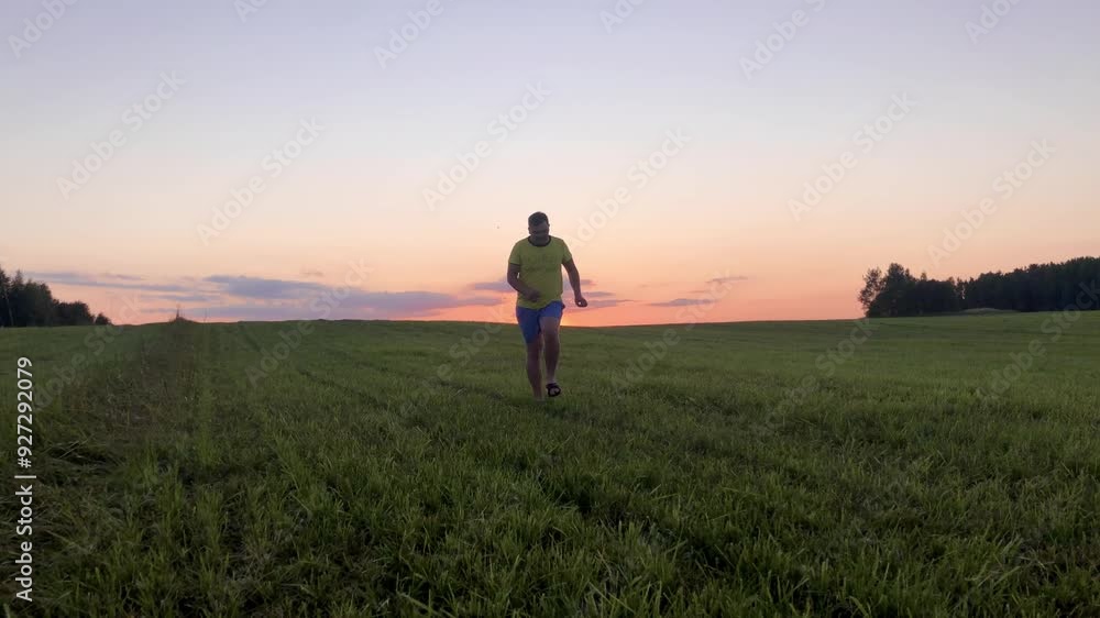 Man goes towards the camera dancing in the field against the background of sunset. World Sun Day. Day of Unknown Roads Man goes towards the camera dancing in the field against the background of sunset. World Sun Day. Day of Unknown Roads