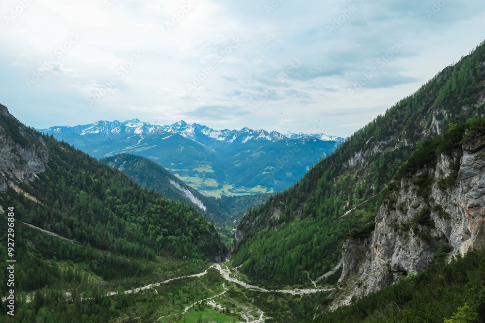 Scenic aerial view of majestic alpine landscape with snow-capped mountain ridges of Schladminger Tauern in Ramsau am Dachstein, Styria, Austria. Hiking trail through alpine greenery in Austrian Alps Scenic aerial view of majestic alpine landscape with snow-capped mountain ridges of Schladminger Tauern in Ramsau am Dachstein, Styria, Austria. Hiking trail through alpine greenery in Austrian Alps