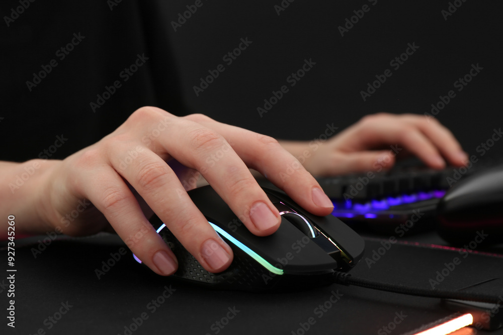 Gamer using modern wired computer mouse at dark table, closeup Gamer using modern wired computer mouse at dark table, closeup