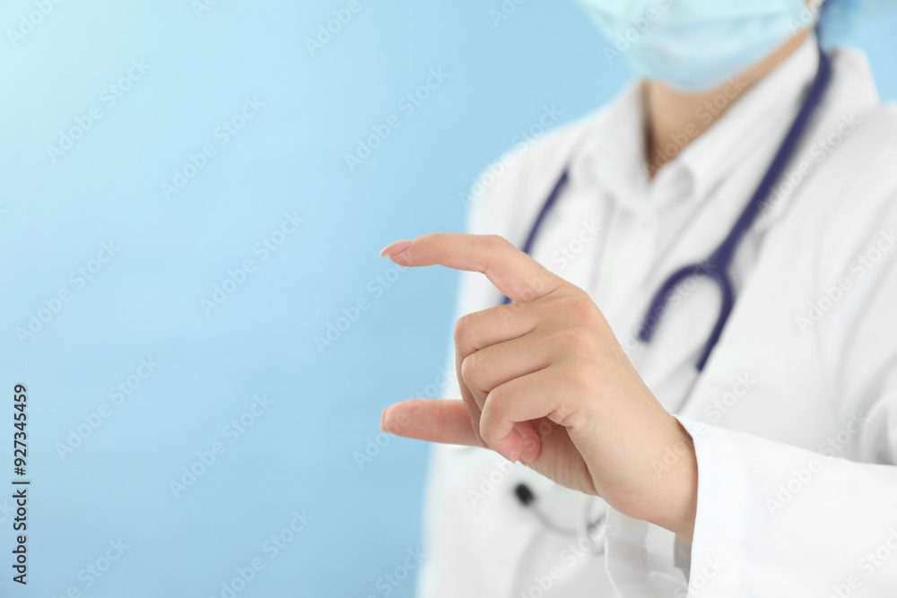 Doctor holding something on light blue background, closeup. Space for text Doctor holding something on light blue background, closeup. Space for text