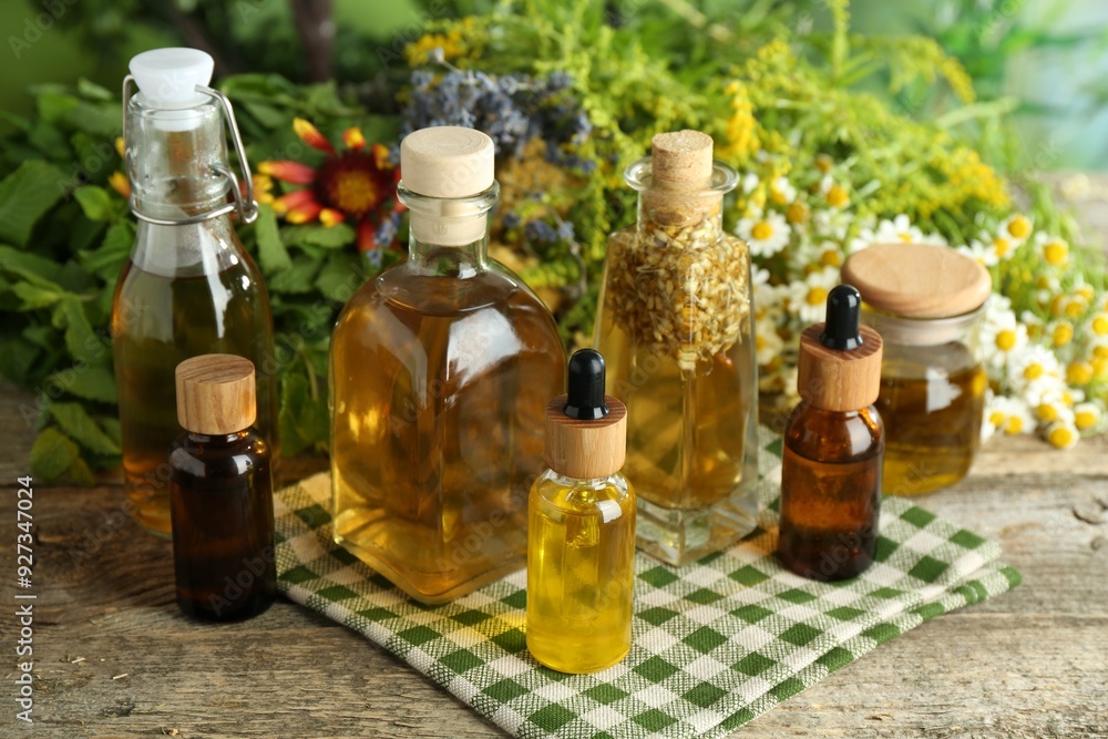 Different tinctures in bottles and medicinal herbs on wooden table Different tinctures in bottles and medicinal herbs on wooden table