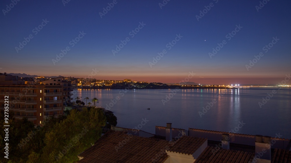 Obraz premium Panoramic image of the rising sun over the sea on a coast with buildings