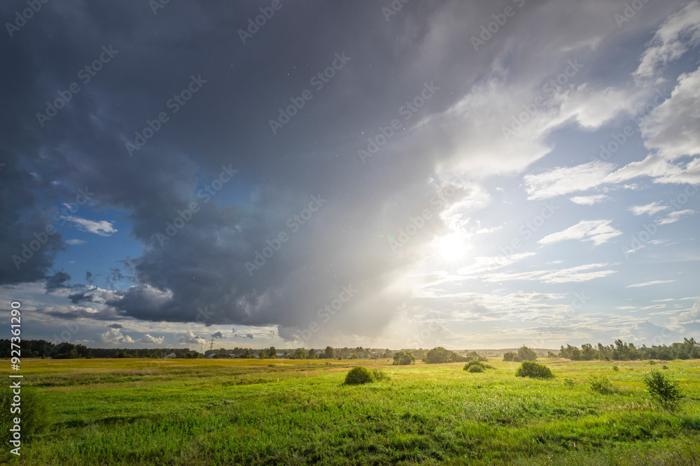 Obraz premium A field of grass with a storm in the distance