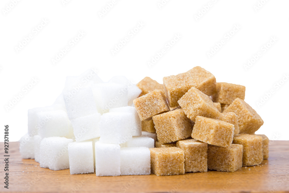 Sugar cubes on a wooden board, isolated on white background. Brown and white sugar. Sugar cubes on a wooden board, isolated on white background. Brown and white sugar.