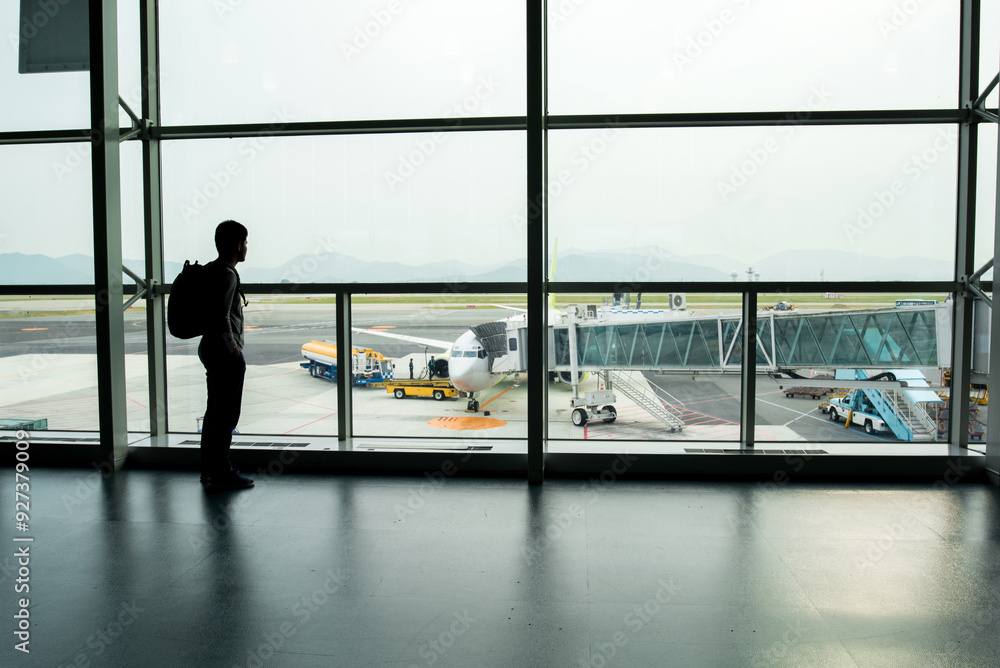 Fototapeta premium travel,Backpack tourists waiting flight on the gate in airport for summer trip.trip Summer flight on the gate in airport Background.