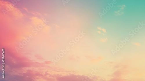 A pastel-colored sky at sunset with soft clouds over a tranquil landscape