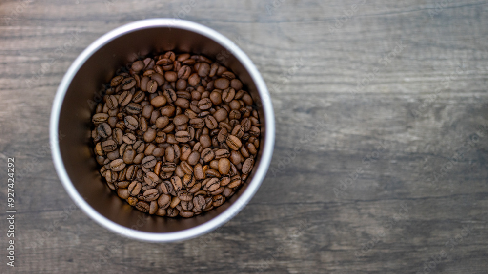 Top View of Fresh Coffee Beans in a Metal Container on Wooden Surface with copy space Top View of Fresh Coffee Beans in a Metal Container on Wooden Surface with copy space