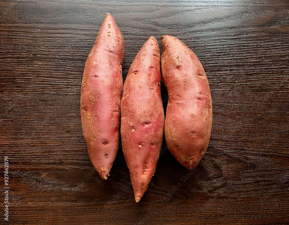 Sweet potato isolated on a dark brown wood surface Sweet potato isolated on a dark brown wood surface