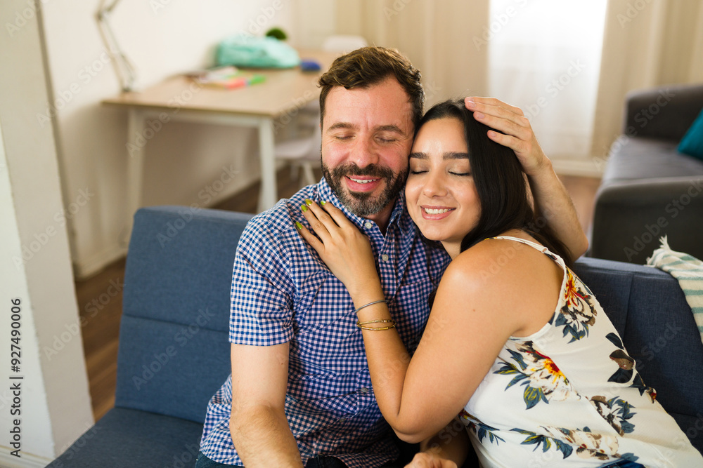 Relaxing young couple embracing on the sofa at home, cherishing their time together Relaxing young couple embracing on the sofa at home, cherishing their time together