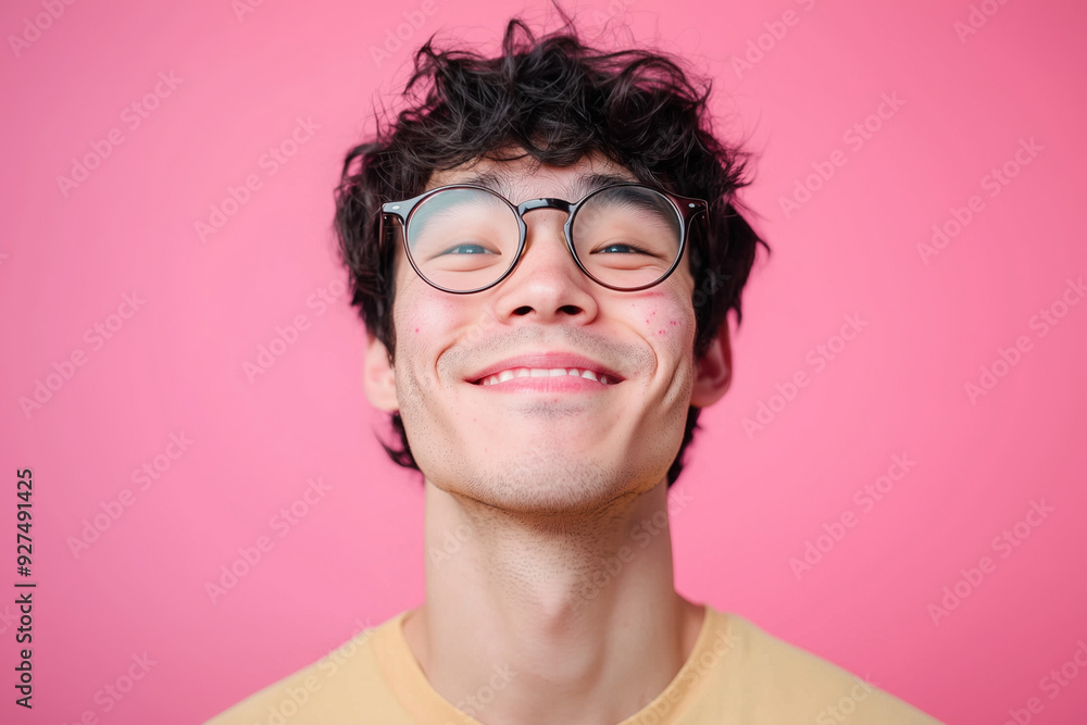 Young Asian teen geek teen with round lens glasses. Smiling. Pink background. Messy black hair. Young Asian teen geek teen with round lens glasses. Smiling. Pink background. Messy black hair.