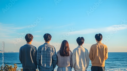 海の前に立つ若い日本人男女グループ