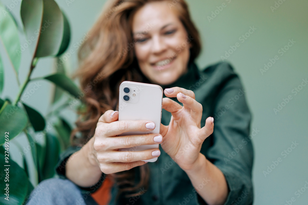 Happy smiling woman scrolls online social media on her mobile phone. Happy smiling woman scrolls online social media on her mobile phone.