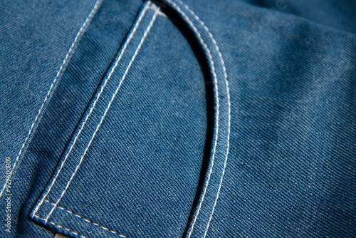 Obraz na płótnie Close-up of blue denim fabric with visible stitching, capturing the texture and detail of the material. w salonie