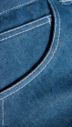 Obraz na płótnie Close-up of blue denim fabric with visible stitching, capturing the texture and detail of the material. w salonie