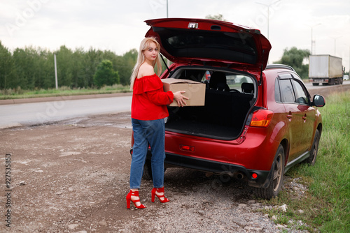 girl puts the box in the trunk photo