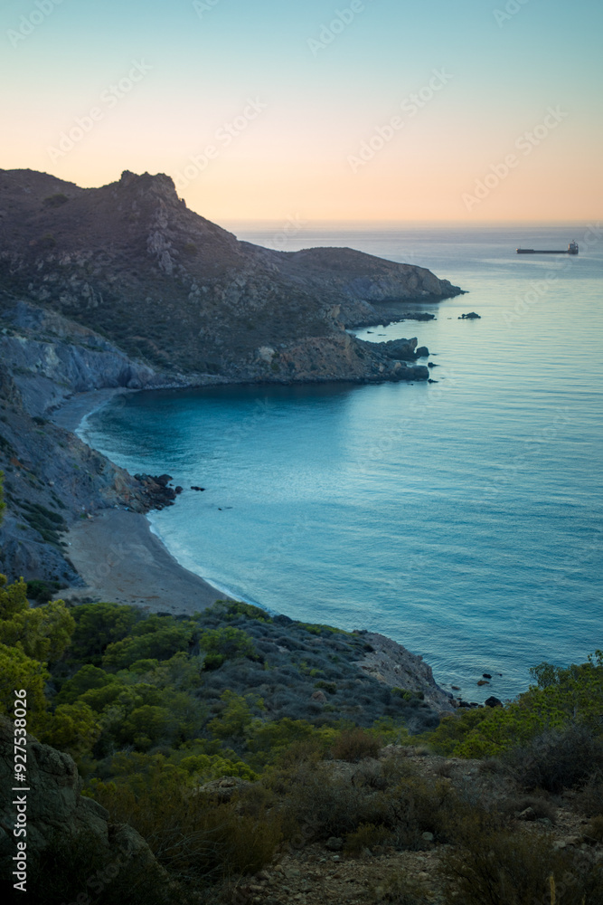 Fototapeta premium Vertical view from above of the stunning Fatares beach in Cartagena, Murcia Region, Spain, in summer with sunrise light