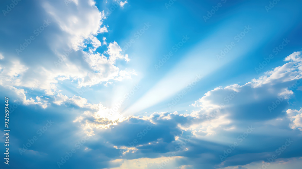 Obraz premium Sun Rays Shining Through Clouds in a Clear Blue Sky