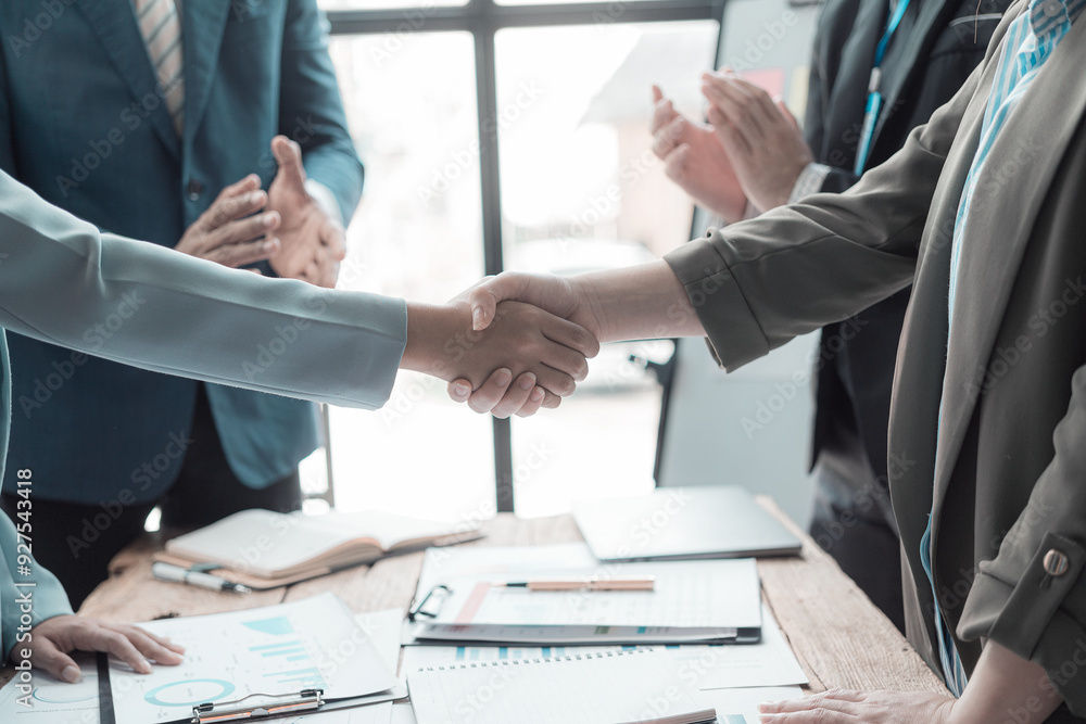 Businessmen holding hands having documents with graphs and financial charts, concept of business agreement together, close-up image. Businessmen holding hands having documents with graphs and financial charts, concept of business agreement together, close-up image.