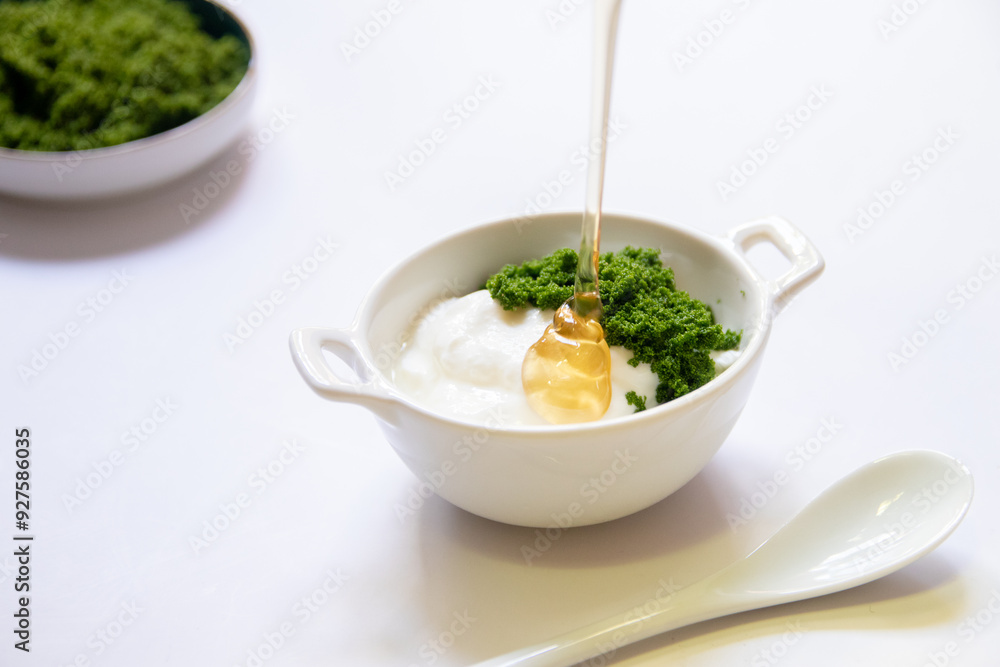 Greek yogurt and wolffia globosa in ceramic bowl isolated on white table background. Wolffia is the nutrient-rich plant-based source of protein and omega3 and vital minerals. Healthy and easy meal. Greek yogurt and wolffia globosa in ceramic bowl isolated on white table background. Wolffia is the nutrient-rich plant-based source of protein and omega3 and vital minerals. Healthy and easy meal.