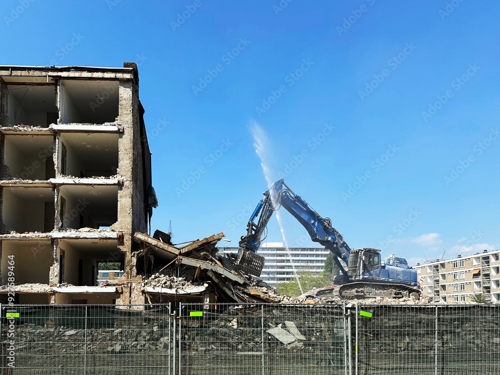 Demolition of building with excavator under blue sky Demolition of building with excavator under blue sky