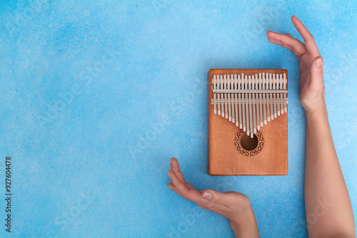 Female hands with a kalimba on a blue background photo