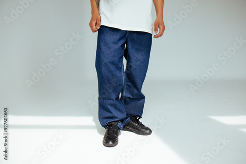 Obraz na płótnie Fashion forward people concept with male model in well-fitted dark blue regular jeans. The design showcases comfort and style in everyday dark denim wear. w salonie