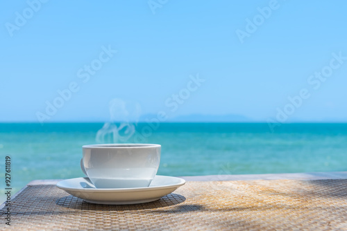 Fototapeta Naklejka Na Ścianę i Meble -  Coffee cup with beautiful sea beach background in the morning holiday vacation summer time.