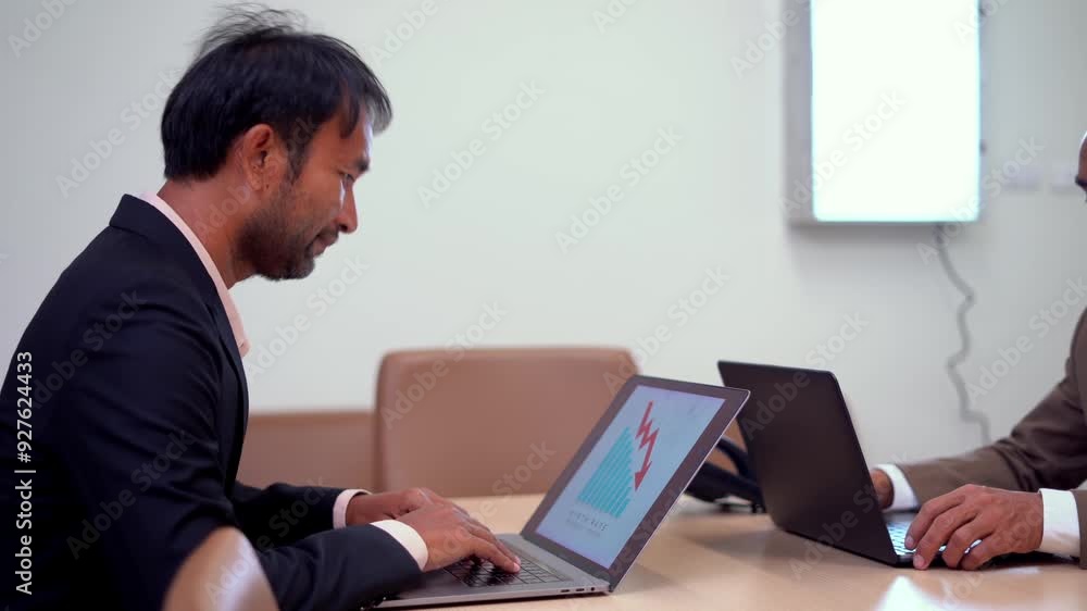 Two business professionals work on laptops at a conference table, deeply focused on their tasks. The image emphasizes productivity, concentration, and the use of technology in a modern office. Two business professionals work on laptops at a conference table, deeply focused on their tasks. The image emphasizes productivity, concentration, and the use of technology in a modern office.