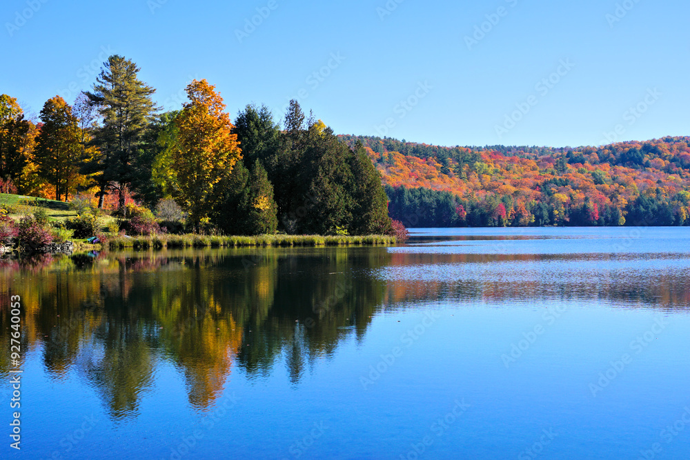 Beautiful fall colors along a lake with reflections in the countryside of Vermont, USA Beautiful fall colors along a lake with reflections in the countryside of Vermont, USA