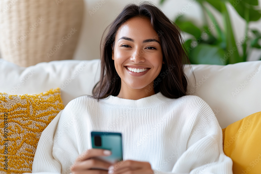 Woman smiling while using smartphone at home Woman smiling while using smartphone at home
