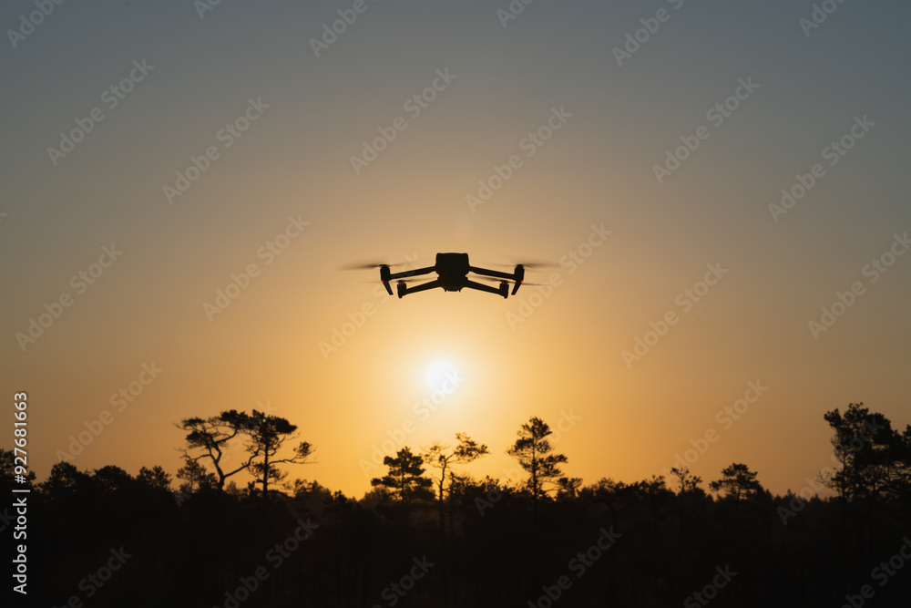 Silhouette of a drone Quadcopter against the backdrop of sunrise in nature in summer. Silhouette of a drone Quadcopter against the backdrop of sunrise in nature in summer.