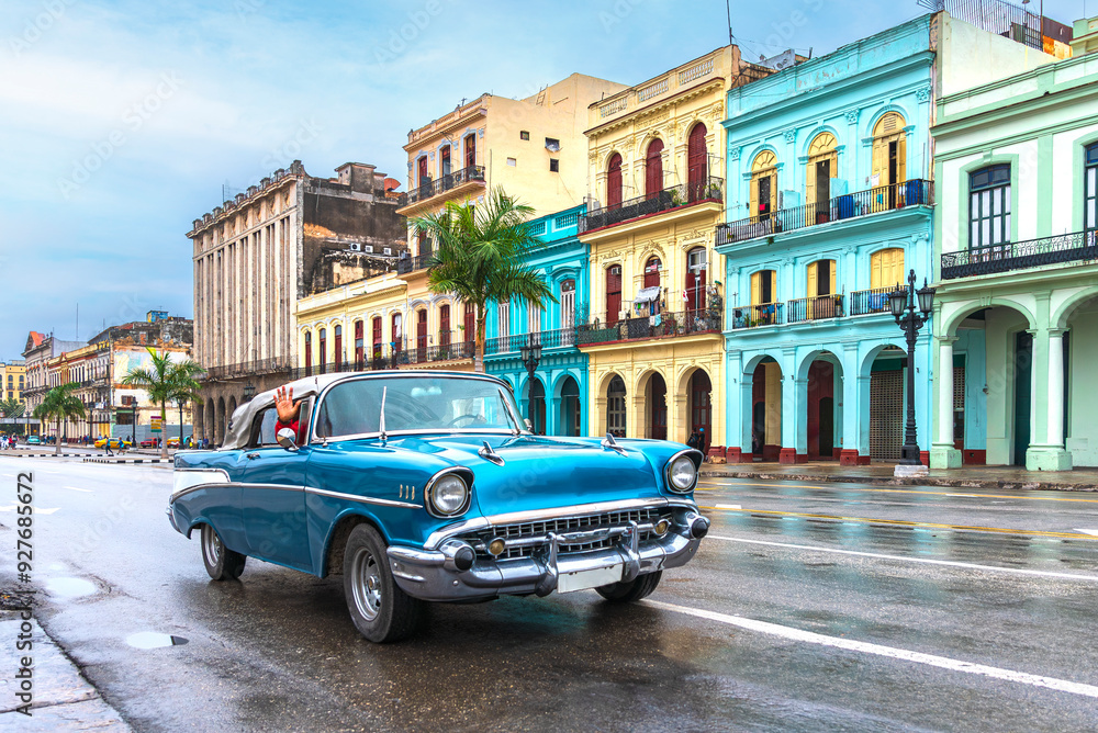 blue convertible classic car in front of colorful houses on a rainy day in havana cuba blue convertible classic car in front of colorful houses on a rainy day in havana cuba