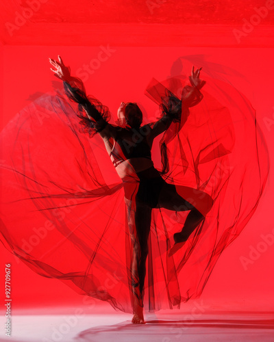 Obraz na płótnie Graceful Dancer in Red Hue - An artistic portrayal of a dancer’s silhouette, showcasing the beauty of dance through soft, flowing lines and a bold, red backdrop