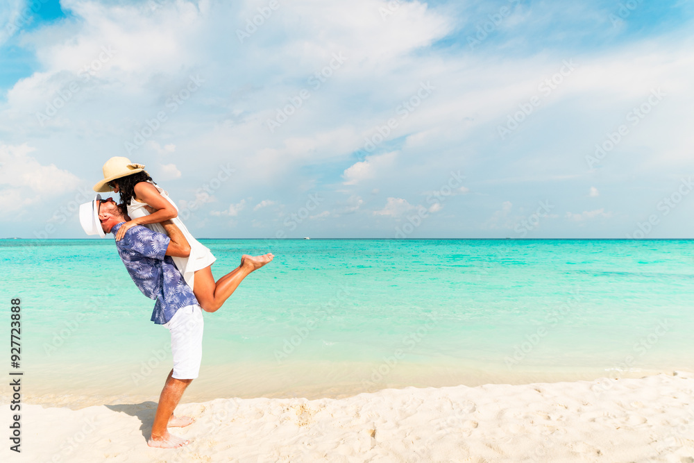 Young happy couple on white beach at summer vacation having fun laugh enjoy vacation on white sand beach by turquoise ocean waters. Private island sunny summer season holidays Young happy couple on white beach at summer vacation having fun laugh enjoy vacation on white sand beach by turquoise ocean waters. Private island sunny summer season holidays
