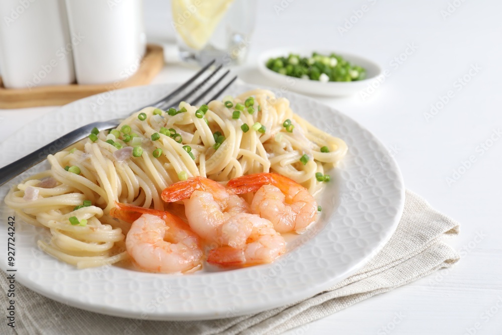 Delicious pasta with shrimps and green onions on white table, closeup Delicious pasta with shrimps and green onions on white table, closeup