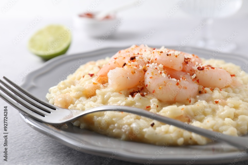 Delicious risotto with shrimps and cheese on light grey table, closeup Delicious risotto with shrimps and cheese on light grey table, closeup