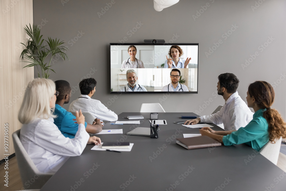 © fizkes - Virtual meeting event of diverse medical internists professionals, communicate remotely using videoconference application, gathered together in boardroom of clinic. Opinion, exchange, decision-making