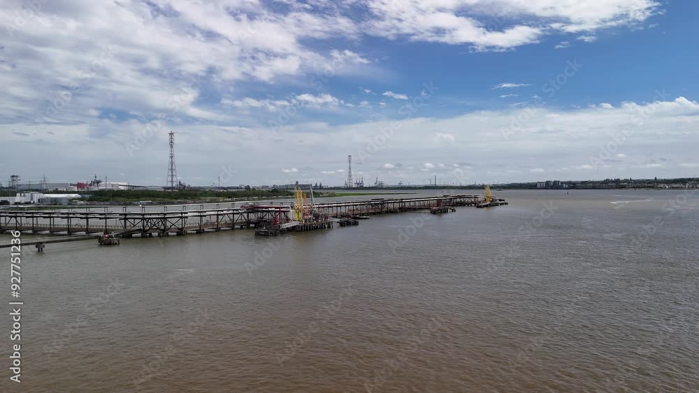 Drone heading along the River Thames, over an industrial pier under a blue clear sky in Dartford, UK Drone heading along the River Thames, over an industrial pier under a blue clear sky in Dartford, UK