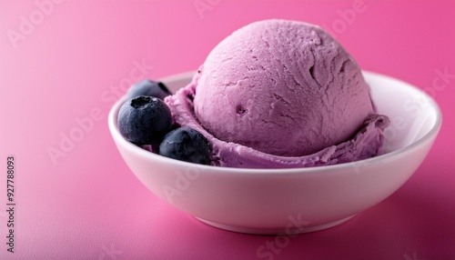 Close-up of a single scoop of blueberry ice cream in a white ceramic bowl on a smooth pink b