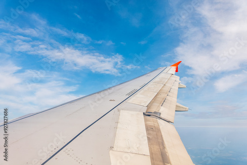 View from the airplane window at a beautiful cloudy sky and the airplane wing