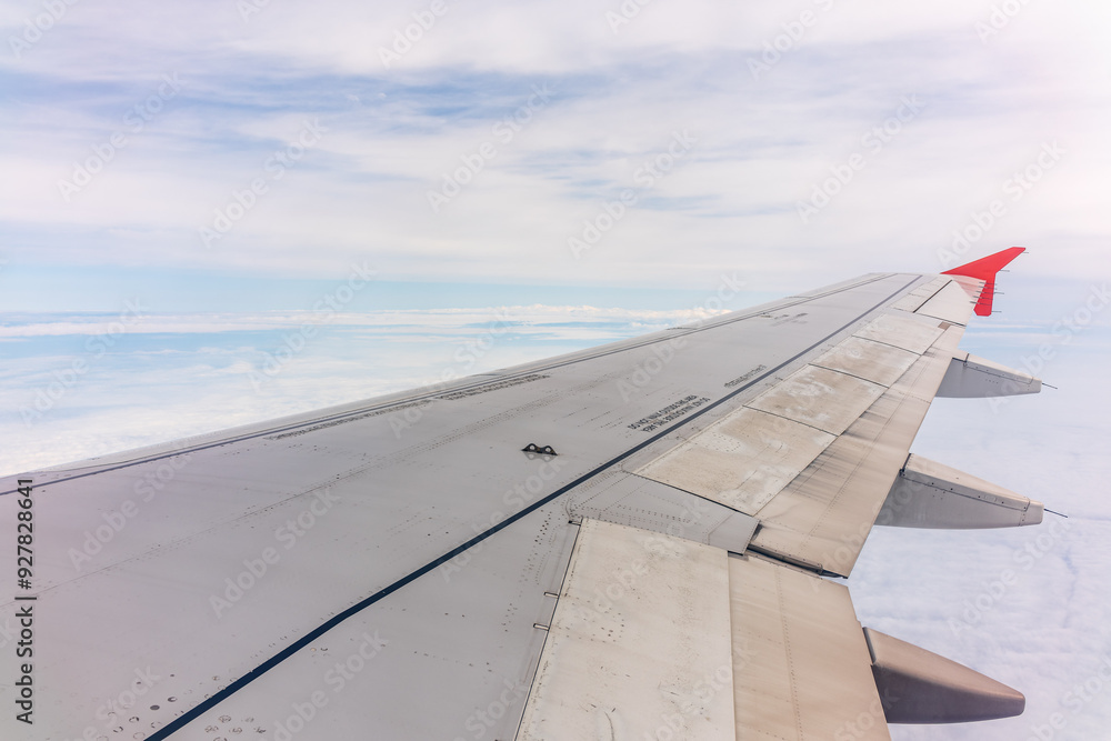 Fototapeta premium View from the airplane window at a beautiful cloudy sky and the airplane wing