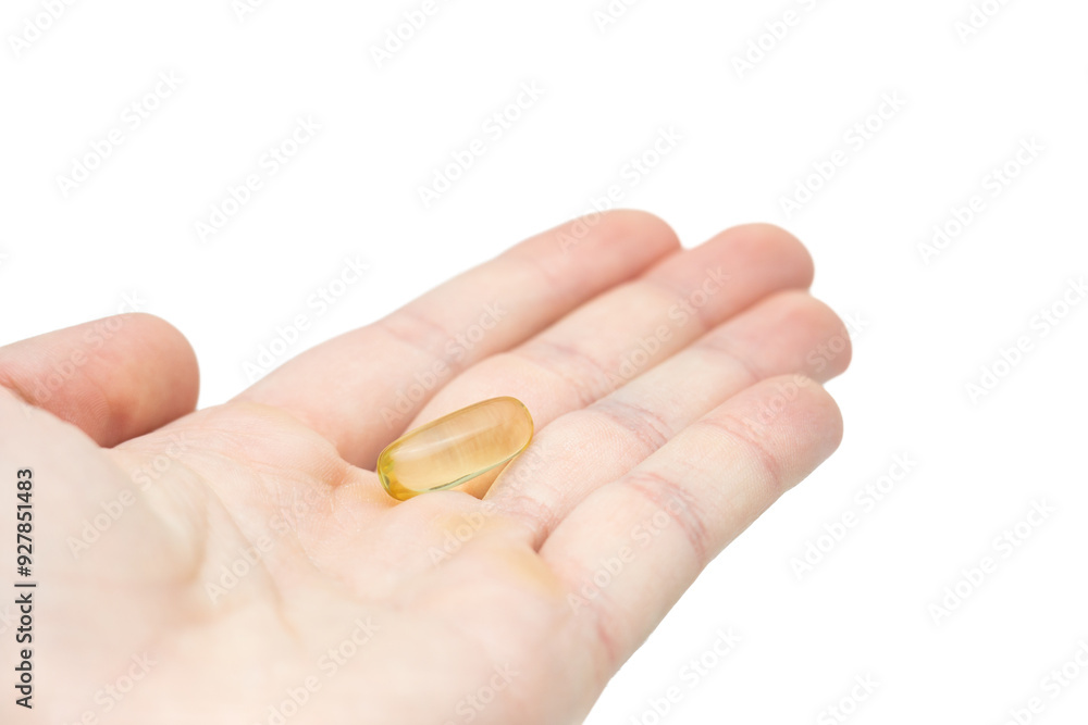 Male hand holding omega 3 soft gel capsule isolated on white background Male hand holding omega 3 soft gel capsule isolated on white background