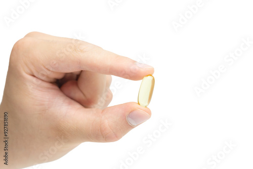 Male hand holding omega 3 soft gel capsule isolated on white background