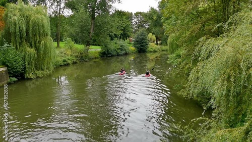 Two kayaks floating down the river in the park. photo