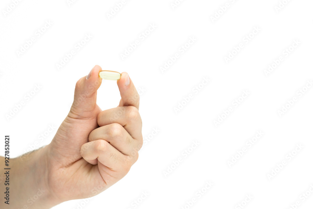 Male hand holding omega 3 soft gel capsule isolated on white background Male hand holding omega 3 soft gel capsule isolated on white background