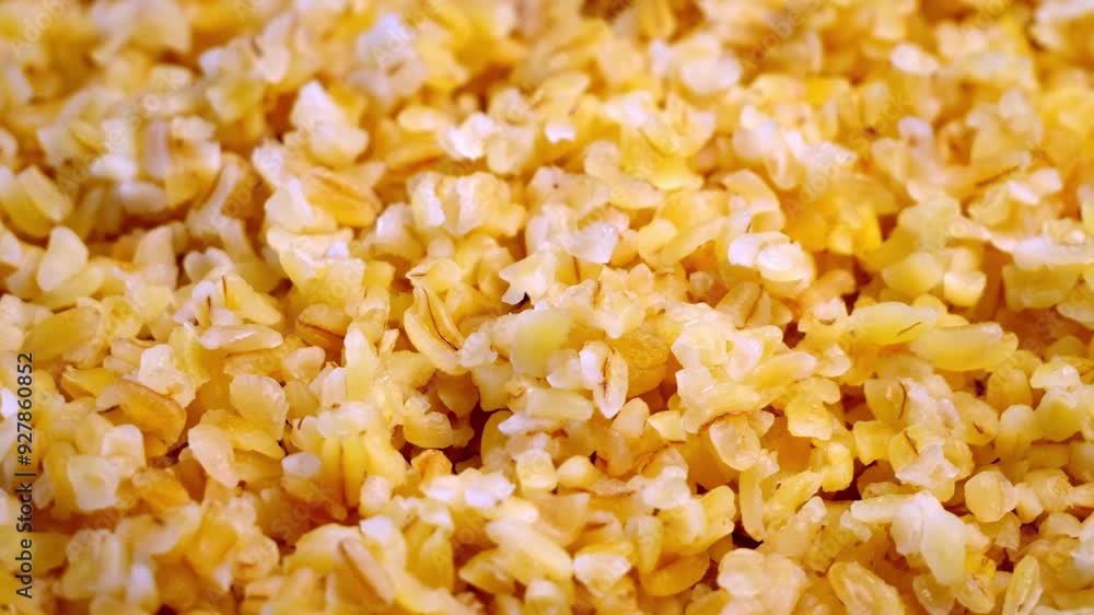 A close-up video of cooked bulgur wheat, showcasing its small, cracked grains and light color. A close-up video of cooked bulgur wheat, showcasing its small, cracked grains and light color.